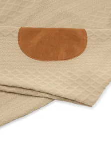 Close-up of beige jacquard men's sweatshirt with brown suede elbow patch detail.