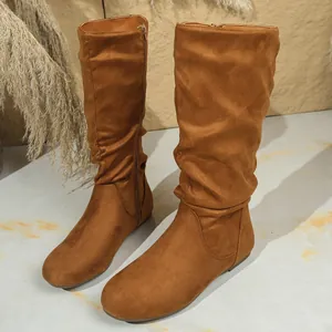 Detailed view of stylish tan suede slouchy boots featuring round toe and side zipper