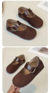 Detail van bruine Mary Jane-schoenen voor meisjes van imitatie-suède met metalen gesp.