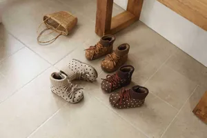 Detail view of retro polka dot suede boots for girls with cozy knit collars and lace-up decor.