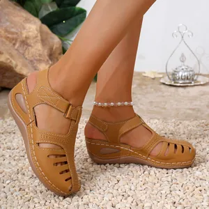 Detail shot of women's tan wedge sandals featuring closed-toe cutouts and contrast stitching