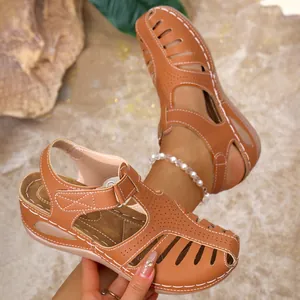 Close-up detail of brown platform wedge sandals featuring closed toe and white contrast stitching