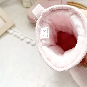 Close-up of thick pink fleece lining and internal size label in warm baby snow boots.