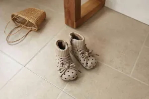 Detailed close-up of retro polka dot girls' winter boots with knit collar and soft laces.