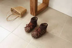 Close-up of retro brown polka dot girl's winter boots with knit collar and warm lining