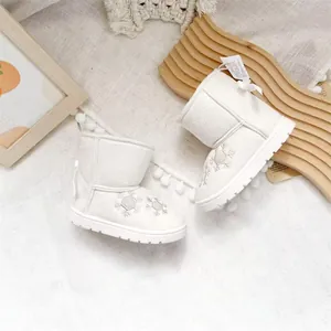 White girls snow boots featuring snowflake embroidery and a decorative bow on the heel