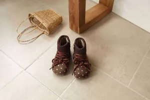 Close-up of retro brown polka dot girls' ankle boots with knit collar and laces