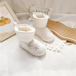 Close-up of kids warm white snow boots with snowflake embroidery and soft fleece lining.