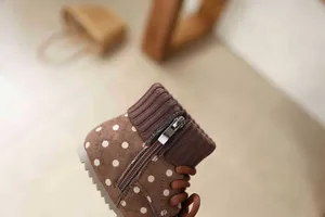 Detailed close-up of girls' retro polka dot suede boots featuring a zipper and knit collar