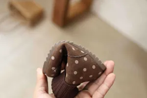 Detailed shot of flexible brown polka dot suede boots with knit collar for girls