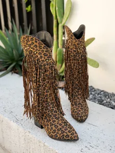 Detailed view of leopard print western boots with retro fringe and stud accents