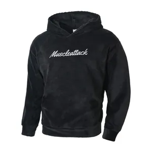 Detailed view of black fleece hoodie featuring white cursive Muscleattack embroidery.
