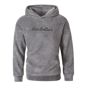 Detail shot of a fuzzy gray fleece hoodie with black Muscleattack chest embroidery