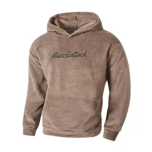 Detail of a brown fleece hoodie with Muscleattack embroidery and soft plush texture.