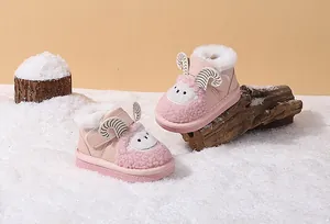 Cute pink cartoon sheep-shaped baby snow boots with warm white fur lining in a snow scene