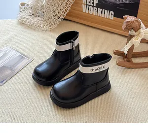 Vue détaillée des bottines Chelsea rétro noires pour enfants avec semelle épaisse et sangle.