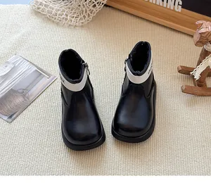 Détail de bottes Martin noires pour enfants avec col blanc et doublure en polaire chaude