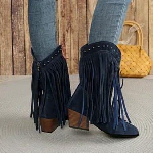 Detailed view of blue suede western mid-calf boots with long fringes and gold rivets.