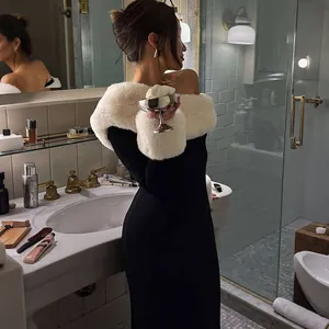 Elegante zwarte off-shoulder jurk met witte imitatiebontkraag en zachte bontmanchetten.