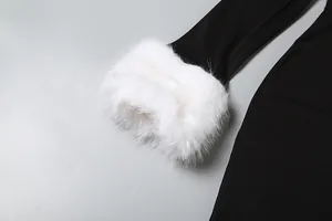 Macro-detailopname van de zachte witte nepbonte manchet op een zwarte jurk mouw.