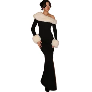 Volledig aanzicht van de elegante zwarte jurk met witte bontkraag en zachte manchetten.
