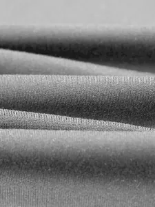 Close-up macro shot of grey breathable sports fabric for men's activewear vest.