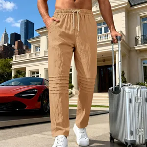 Détail du pantalon en lin plissé beige pour homme avec une valise dans un cadre de luxe