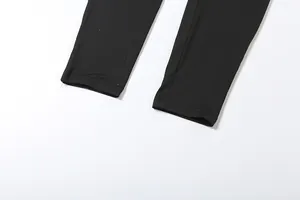 Detailed close-up of the leg cuffs and stitching on a slim black fashion jumpsuit