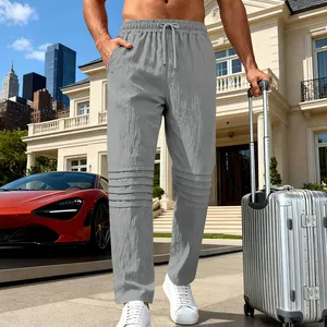 Pantalon en lin gris respirant pour homme avec détails plissés aux genoux, style chic.