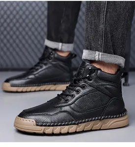 Detail view of men's black pebbled leather Martin boots with decorative stitching and tan soles