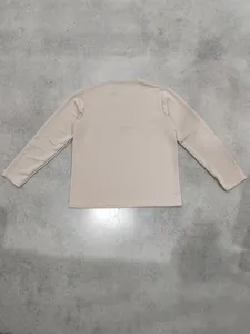 Back view of beige waffle knit long sleeve shirt with a textured jacquard pattern