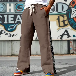 Detailed view of men's brown hip-hop pants with paisley print side snap buttons