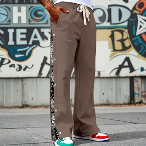 Detailed view of side snap buttons and paisley pattern on brown men's heavy casual pants