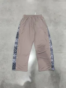 Detailed view of men's heavy hip-hop trousers with paisley panels and snap buttons