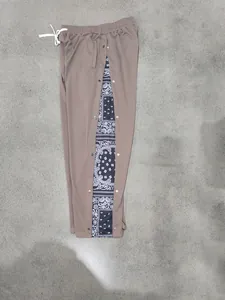 Detail of men's brown hip-hop pants with navy paisley bandana side snap-buttons