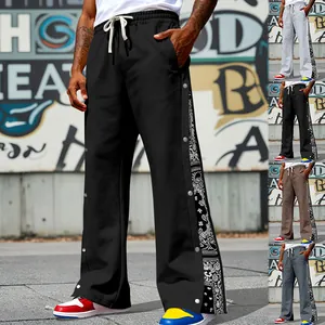 Close-up of men's hip-hop straight pants with paisley pattern and side snap buttons.