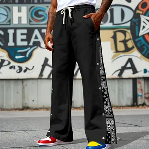 Detailed view of men's hip-hop pants with side snap buttons and paisley side panel