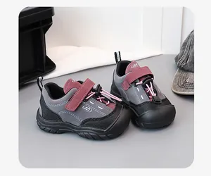Close-up detail of stylish grey and burgundy kids' sneakers with durable soft soles