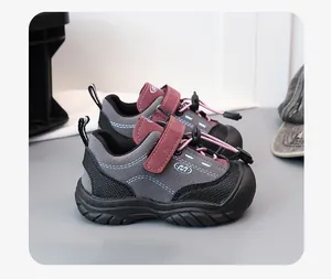 Close-up side view of grey children's hiking shoes with burgundy straps and toggle laces.