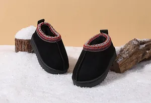 Warm black toddler snow boots with plush lining and braided collar on artificial snow