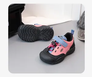 Detail view of pink and blue children's hiking sneakers with soft rubber soles.