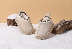 Detail view of plush-lined beige winter boots for toddlers on a snow background