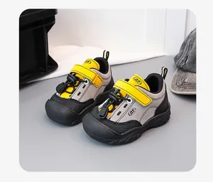 A detailed view of stylish yellow and grey children's sports sneakers with soft durable soles.