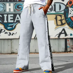Detail view of men's hip-hop sweatpants with side snap buttons and paisley bandana pattern