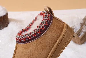 Close-up detail of children's brown snow boots with warm plush lining and trim