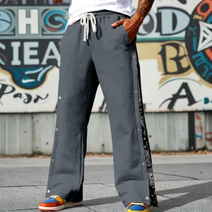 Detailed view of gray heavy hip-hop pants with side snap buttons and paisley pattern.