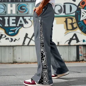 Detailed side view of grey men's hip-hop pants with snap buttons and paisley pattern