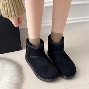 Detalle de botas de nieve de ante negro con forro de piel gruesa para invierno