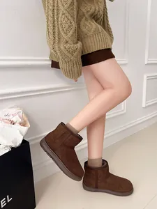 Detalle de botas de nieve de ante marrón con forro cálido grueso y diseño acogedor