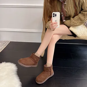 Elegantes botas de nieve de cuero esmerilado marrón para invierno con forro cálido en una modelo